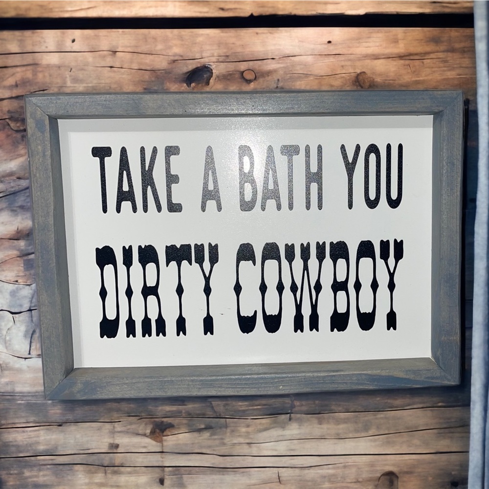 Wooden sign that says, “Take a Bath You Dirty Cowboy”